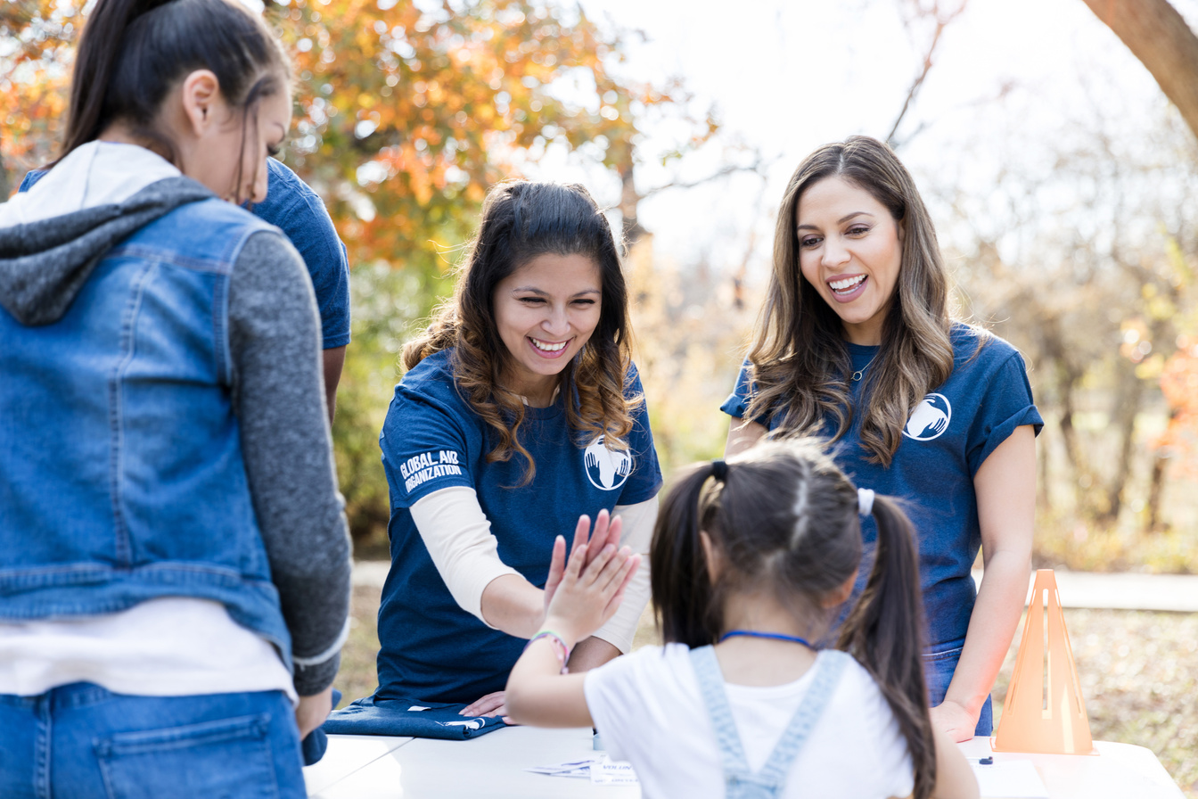 Volunteer coordinator welcomes young girl to event